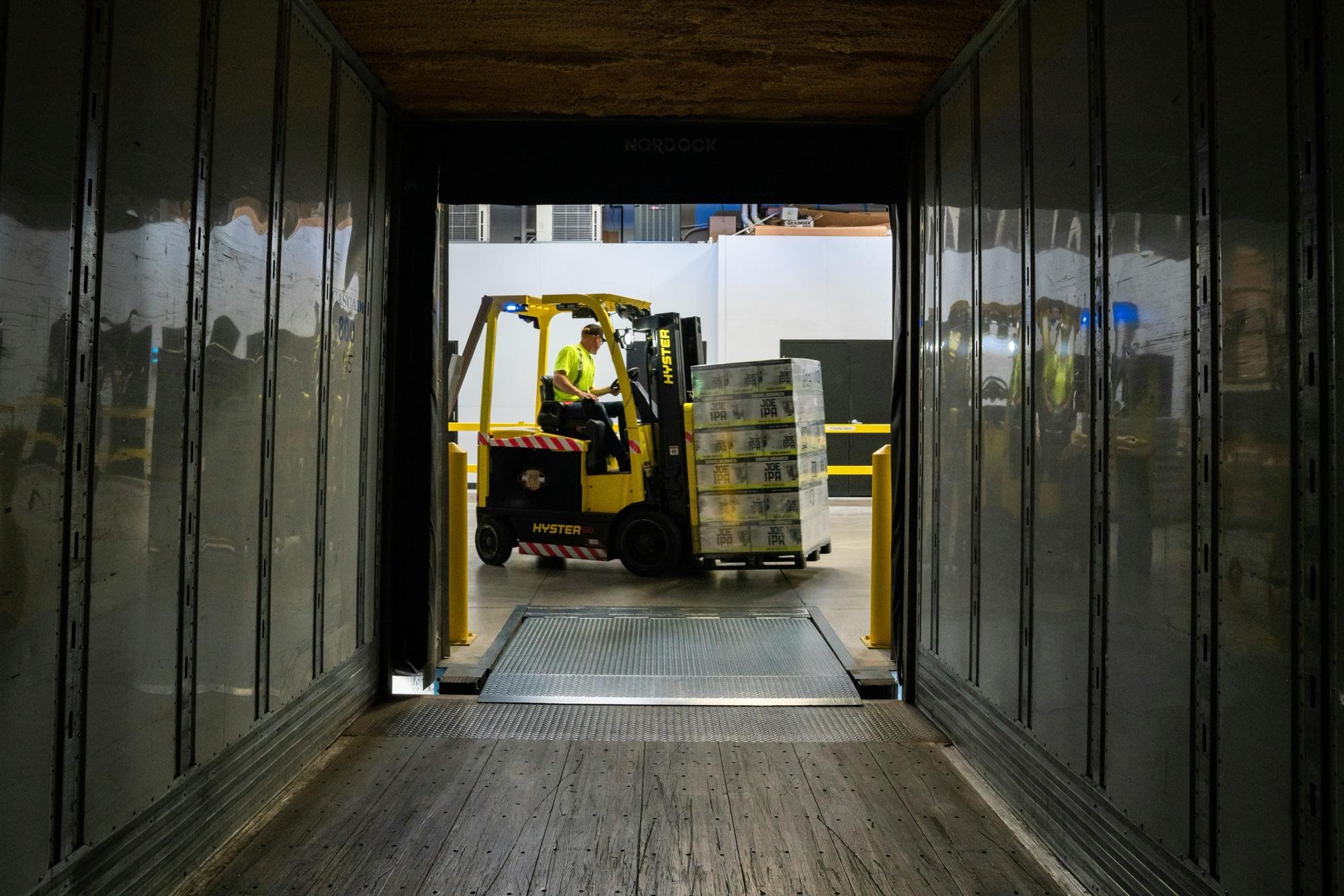 Warehouse staff loading pallets onto a truck for delivery