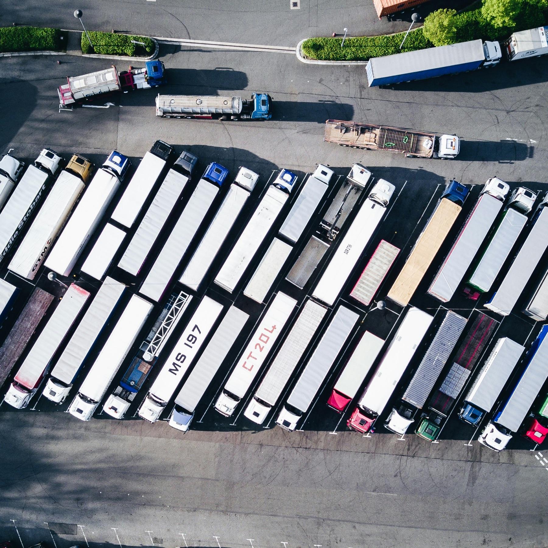 A fleet of commercial delivery trucks at a distribution yard