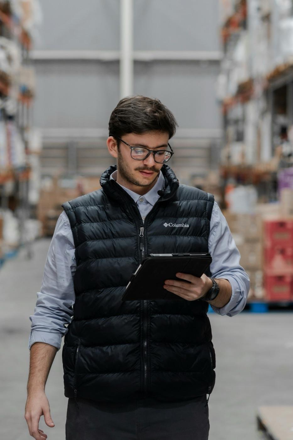 A business operator reviewing inventory in a modern distribution warehouse